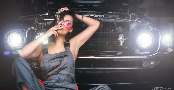 super model Katerina with a cigarette and glasses posing behind a mustang