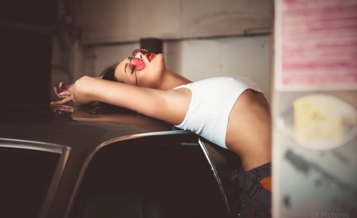 sensual girl Katerina with white top and red glasses in the garage