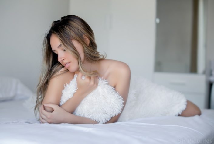 perfect brunette Nellya in the bed with white fur by fred photographe boudoir Paris